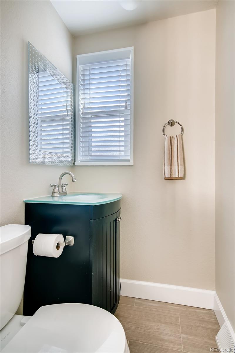 5655 Estes Street Arvada, CO 80002 - Photo 17 of 40 a bathroom with a toilet a sink and mirror