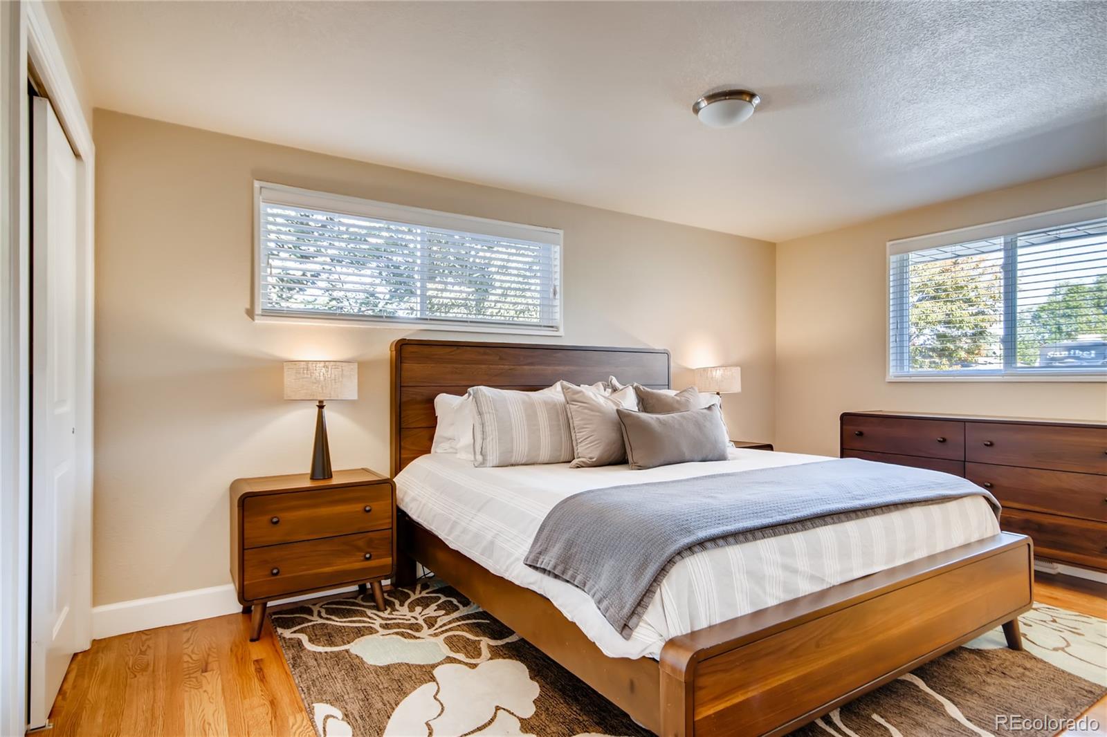 5655 Estes Street Arvada, CO 80002 - Photo 18 of 40 a bedroom with a bed a dresser and a window