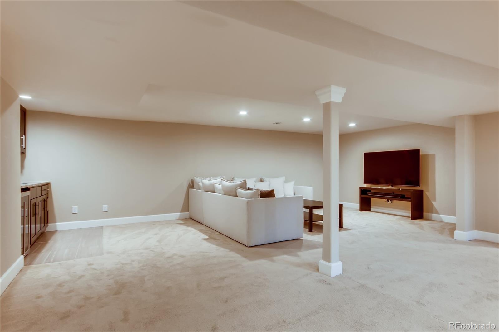 5655 Estes Street Arvada, CO 80002 - Photo 28 of 40 a living room with furniture and a flat screen tv