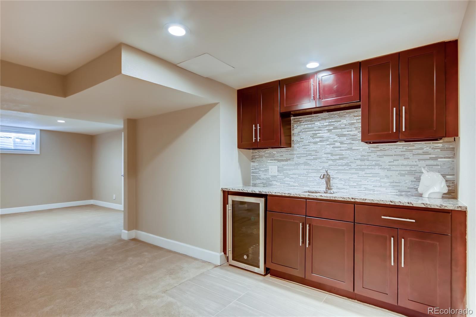 5655 Estes Street Arvada, CO 80002 - Photo 29 of 40 a kitchen with stainless steel appliances granite countertop wooden cabinets a sink and dishwasher