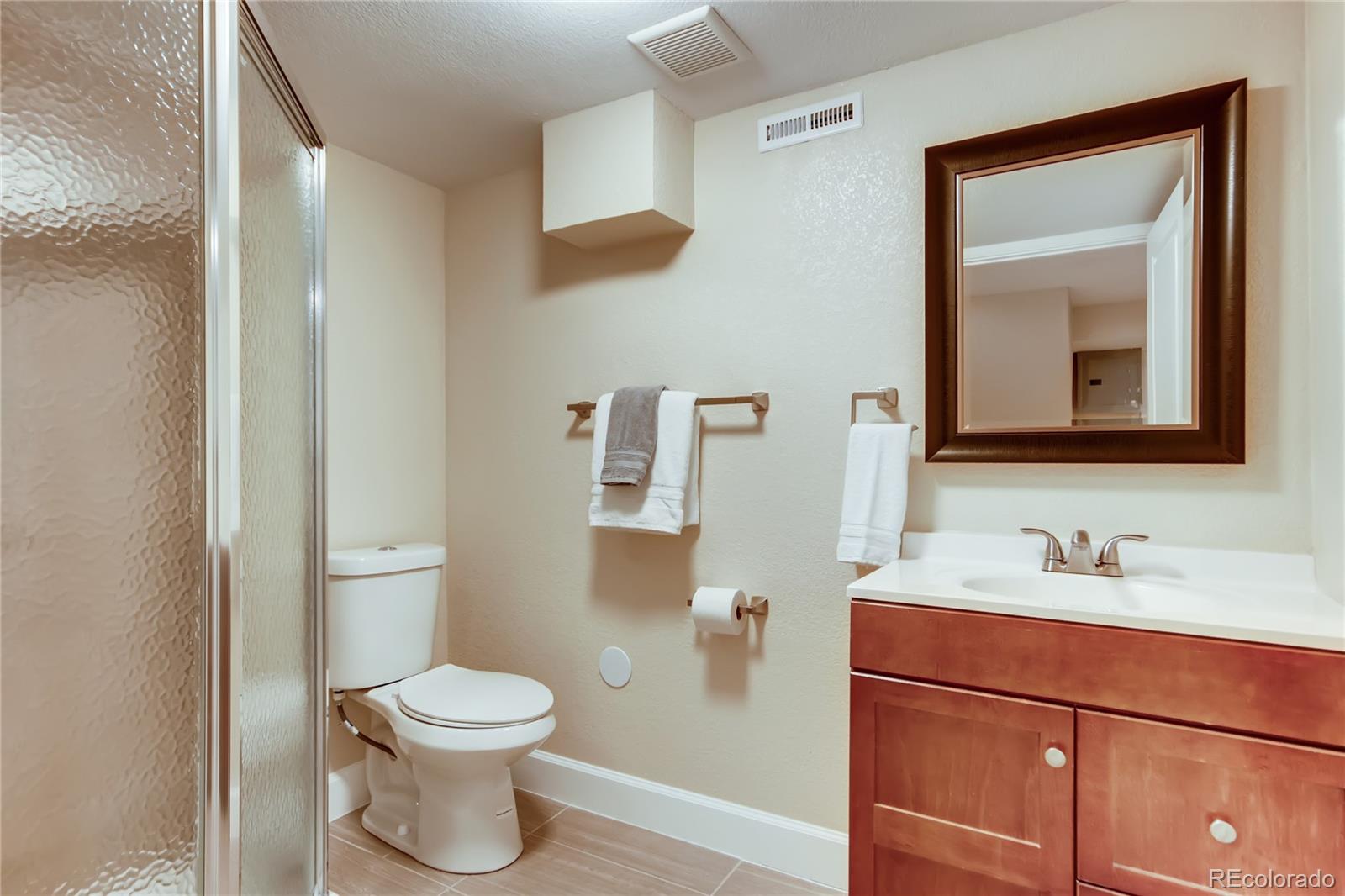 5655 Estes Street Arvada, CO 80002 - Photo 32 of 40 a bathroom with a toilet sink and mirror