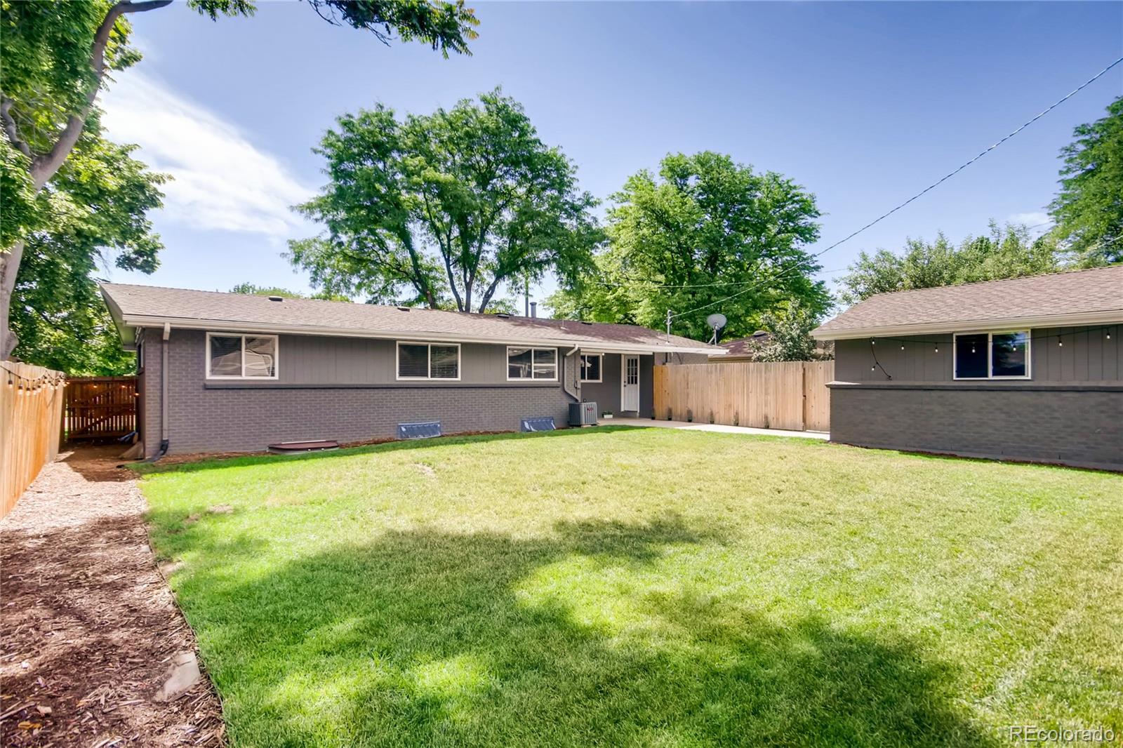 5655 Estes Street Arvada, CO 80002 - Photo 37 of 40 a front view of a house with a yard and trees