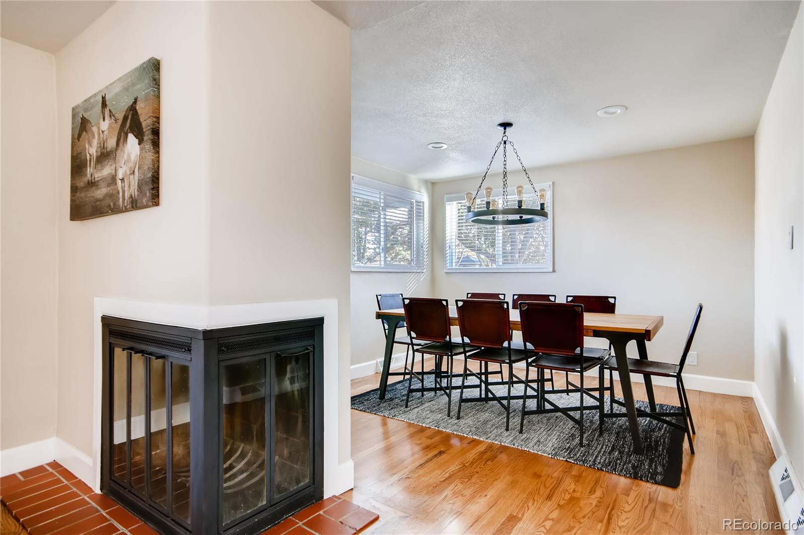 5655 Estes Street Arvada, CO 80002 - Photo 10 of 40 a dining room with furniture a chandelier and wooden floor