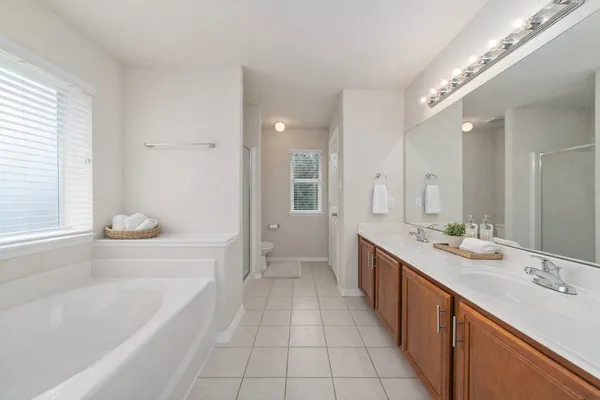 a large spacious bathroom with a double vanity sink a mirror and a bathtub