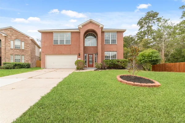a front view of a house with a yard and trees