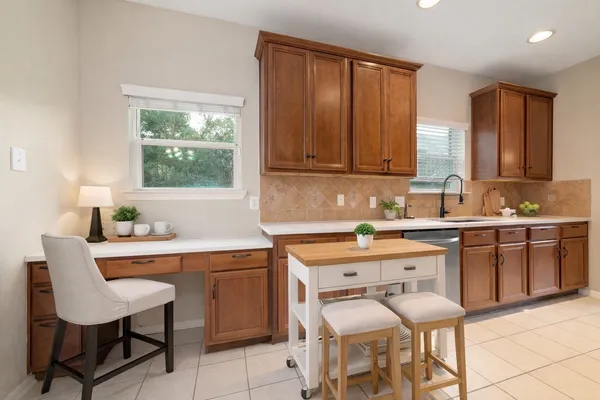 a kitchen with a sink table and chairs