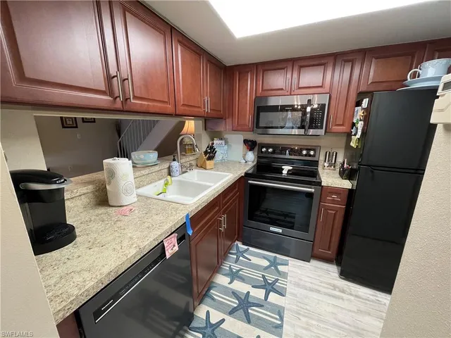 a kitchen with a refrigerator and a stove top oven