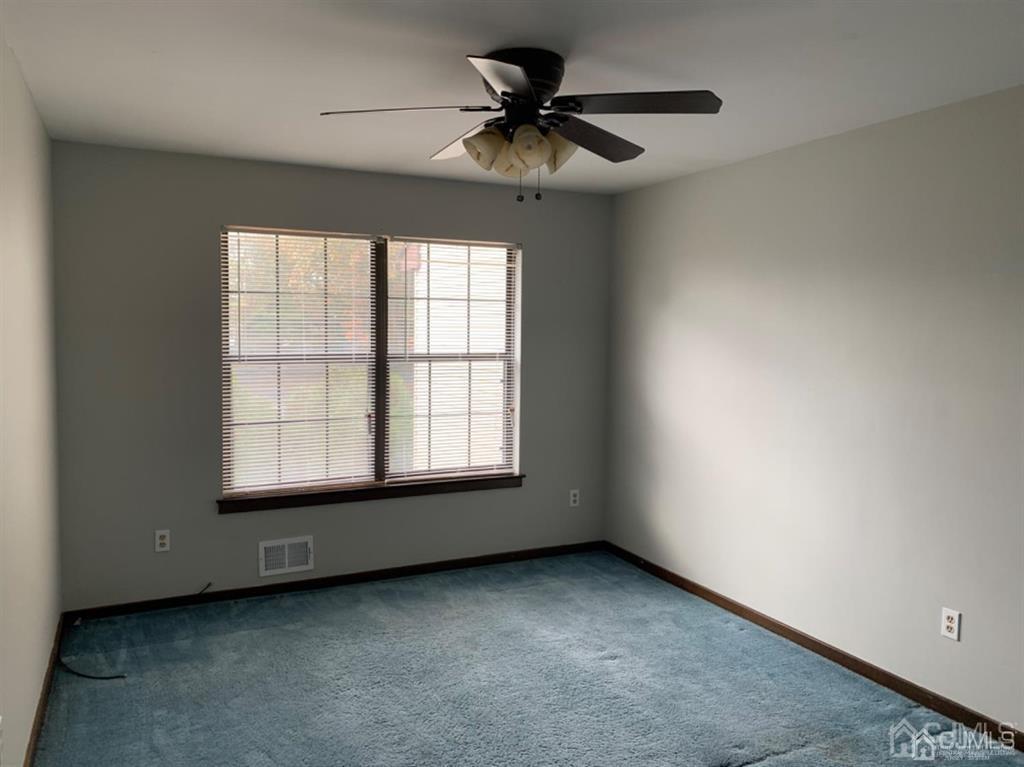 24 Pendleton Place Old Bridge, NJ 08857 - Photo 14 of 22 an empty room with a chandelier fan and windows