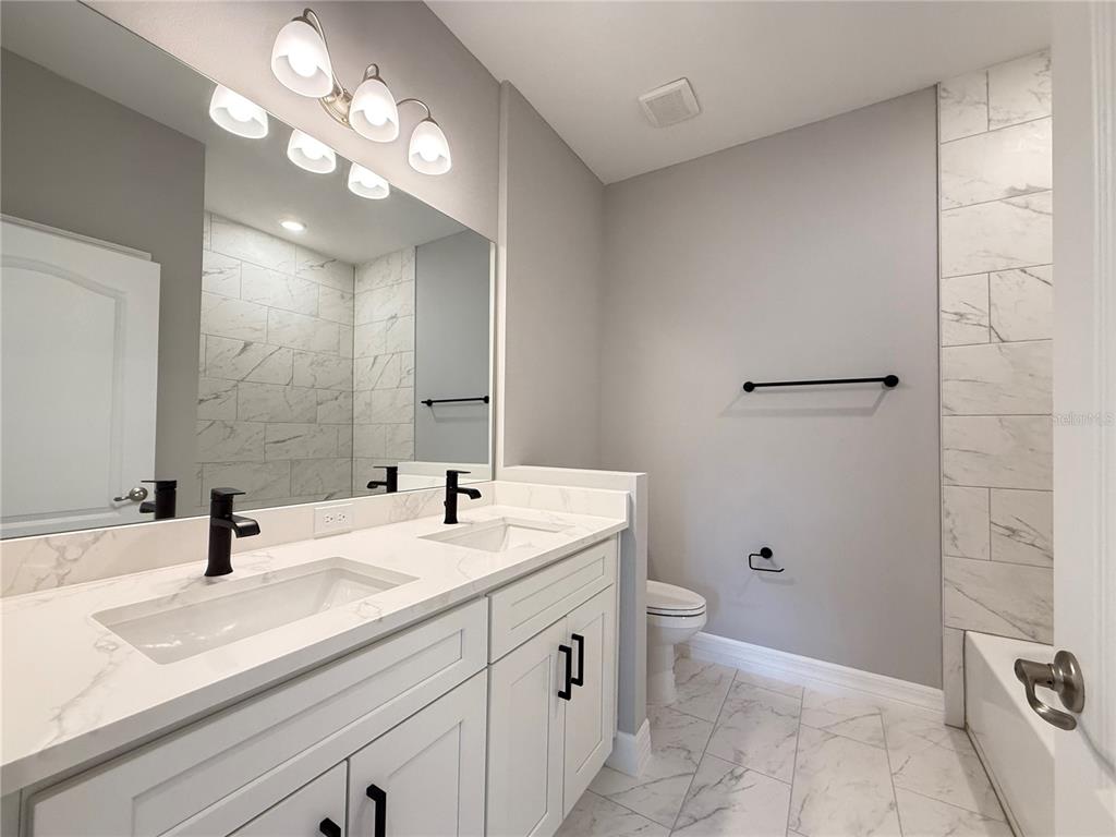 7815 Southwest 128th St Road Ocala, FL 34473 - Photo 11 of 40 a bathroom with a sink a toilet and a mirror