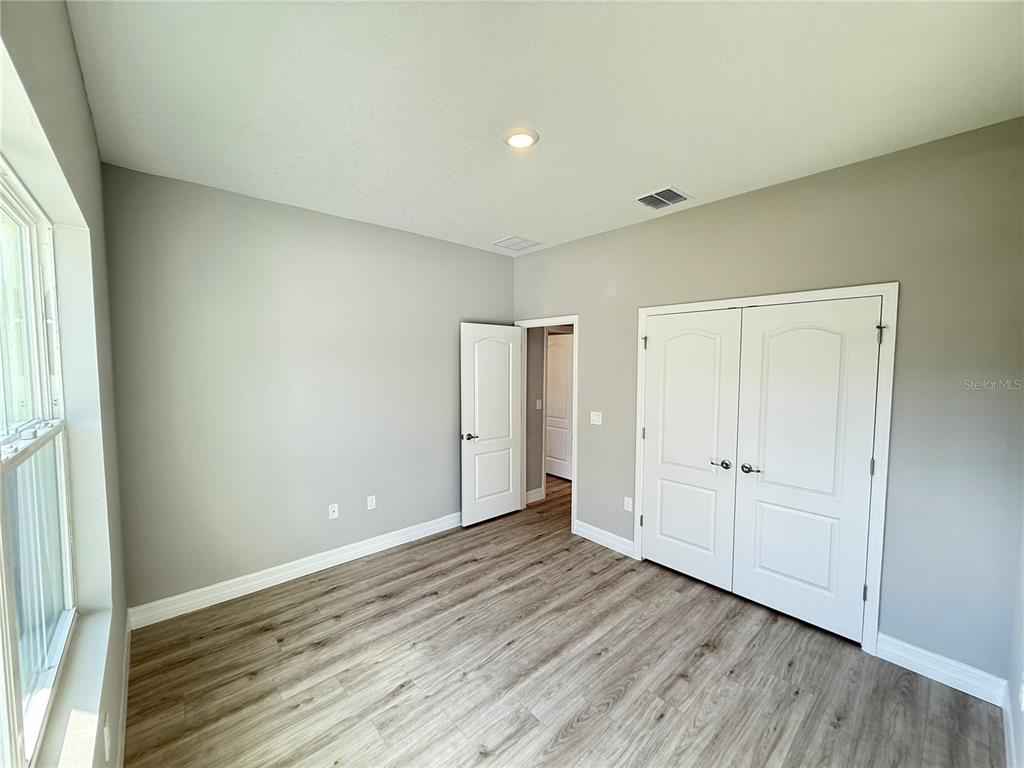 7815 Southwest 128th St Road Ocala, FL 34473 - Photo 19 of 40 an empty room with wooden floor and windows
