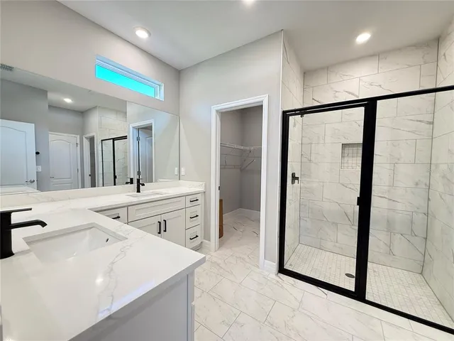 a bathroom with a granite countertop sink mirror and shower