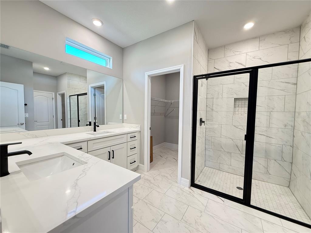 7815 Southwest 128th St Road Ocala, FL 34473 - Photo 23 of 40 a bathroom with a granite countertop sink mirror and shower