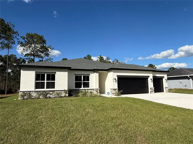 a front view of a house with yard and garage