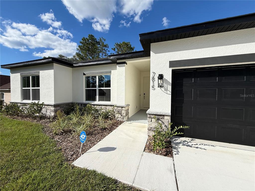 7815 Southwest 128th St Road Ocala, FL 34473 - Photo 4 of 40 a front view of a house with garden
