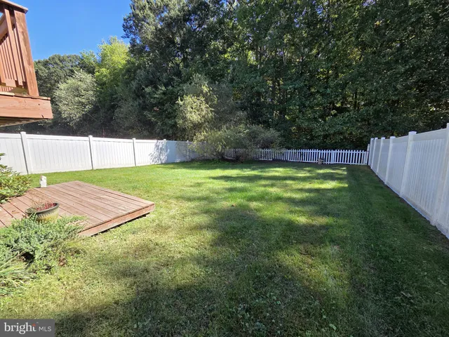 a view of a backyard with white fence