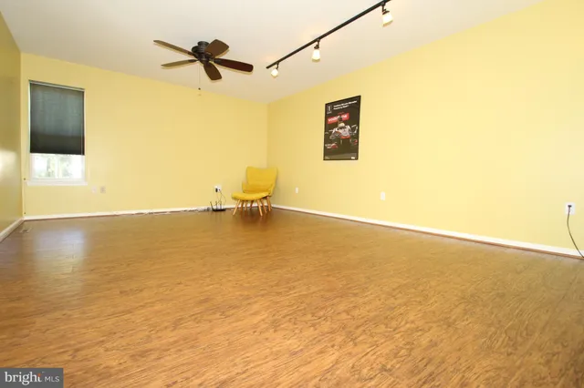 a view of a room with wooden floor and a ceiling fan