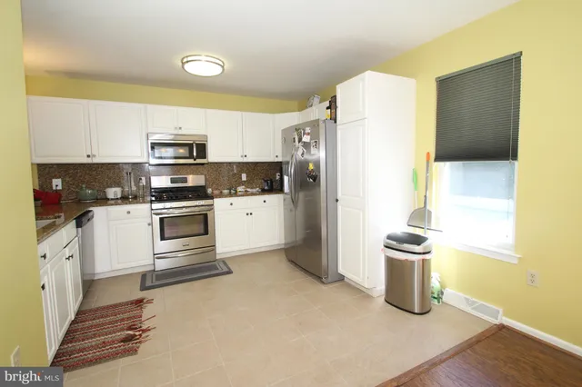 a kitchen with granite countertop a refrigerator stove and sink