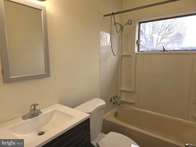 a bathroom with a sink mirror vanity and toilet