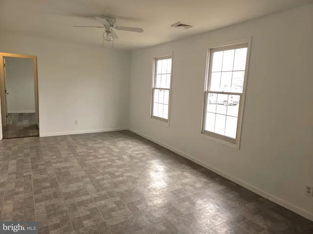 an empty room with windows and closet