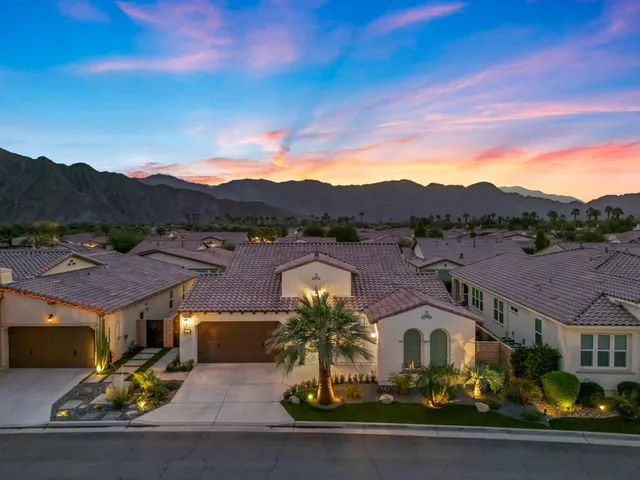 a kitchen with stainless steel appliances kitchen island granite countertop a refrigerator oven a sink a dining table and chairs