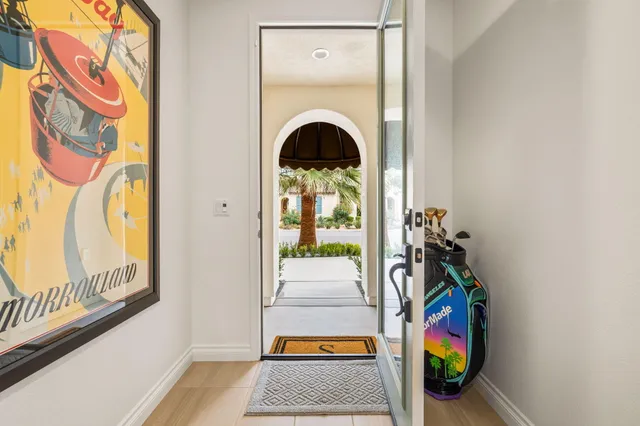 a living room with stainless steel appliances kitchen island granite countertop a large window and white cabinets