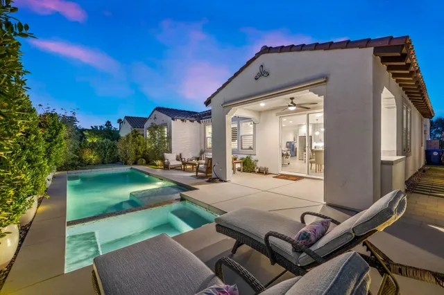 a backyard of a house with potted plants and palm trees