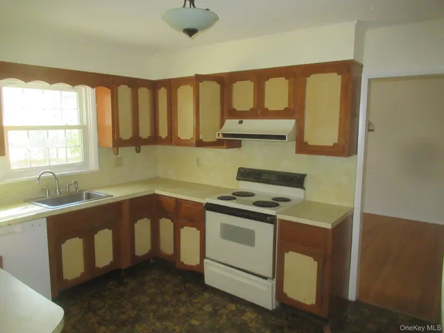 a kitchen with stainless steel appliances granite countertop a sink stove and cabinets