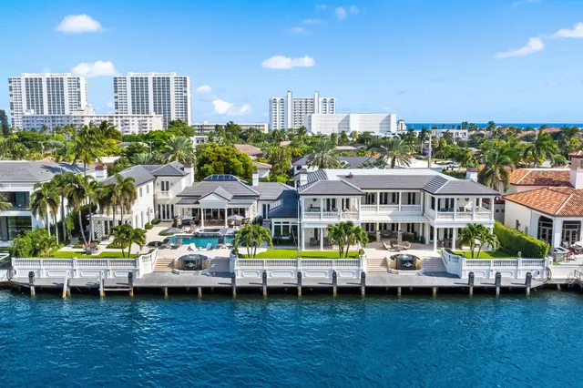 a view of a white house with a yard table and chairs