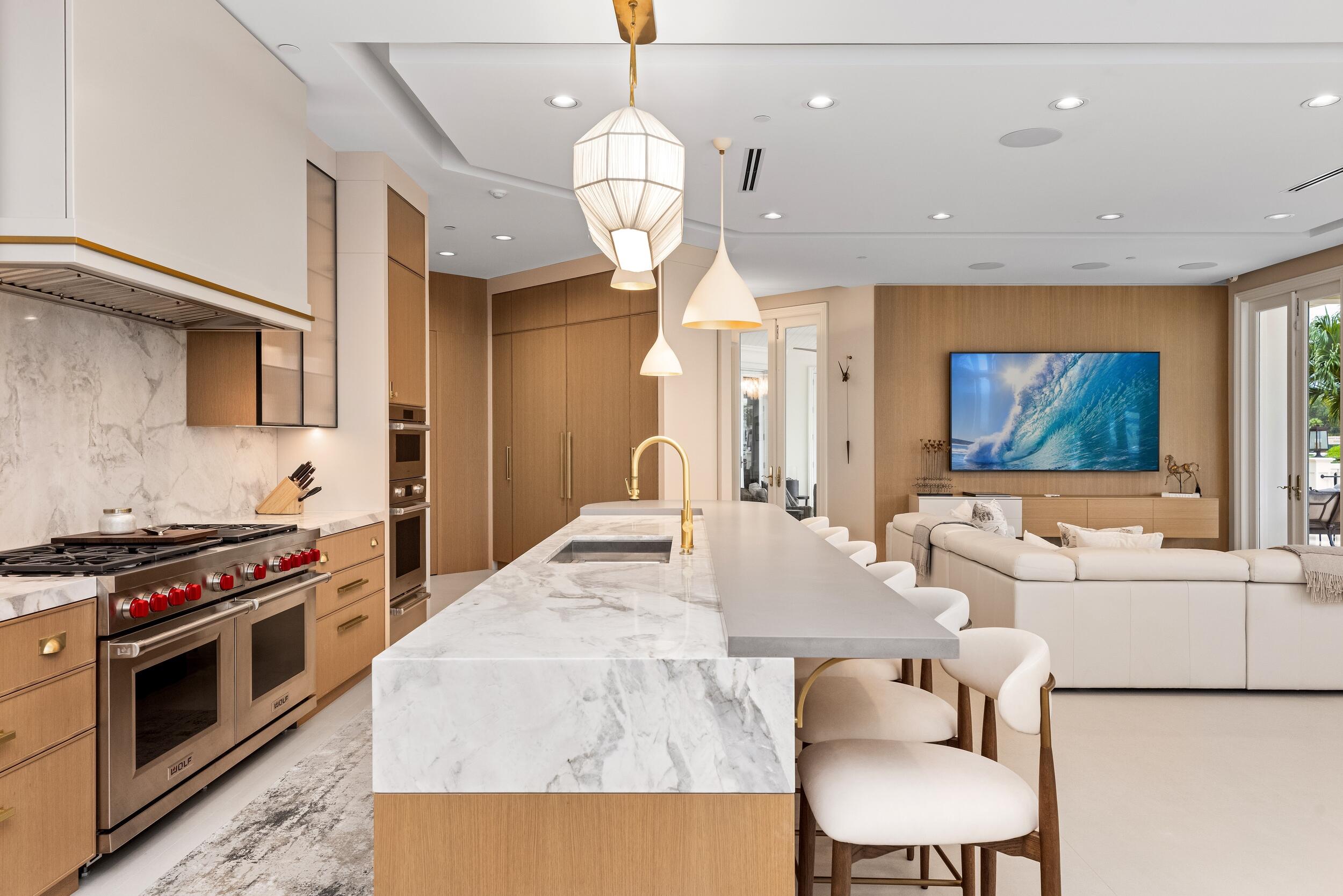 2989 Spanish River Road Boca Raton, FL 33432 - Photo 23 of 130 a kitchen with stainless steel appliances a stove a sink a microwave a refrigerator white cabinets and couches