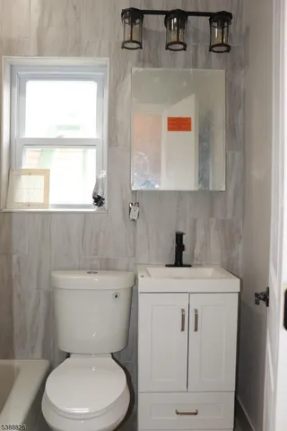 a bathroom with a sink a toilet and a window