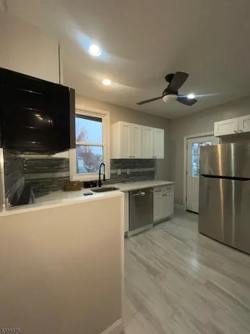 a kitchen with stainless steel appliances granite countertop a refrigerator a sink and a stove