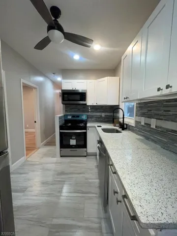 a kitchen with stainless steel appliances kitchen island granite countertop a stove a sink and a microwave