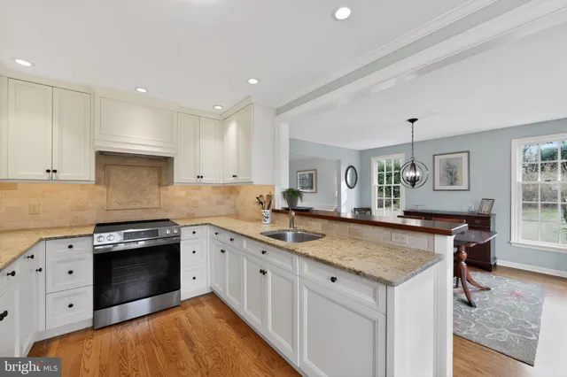 a kitchen with granite countertop kitchen island a sink stove and cabinets