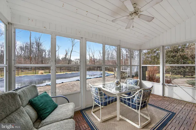 a dining room with furniture a chandelier and glass door