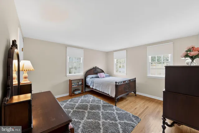 a spacious bedroom with a bed and wooden floor