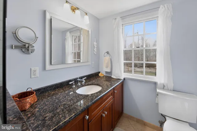 a bathroom with a granite countertop sink and a mirror