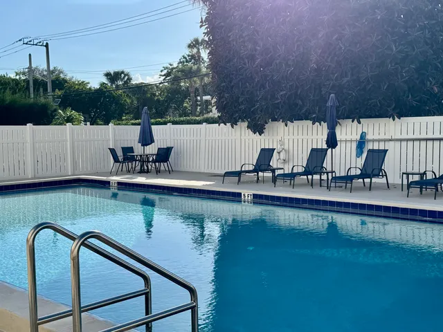 a view of a street with brick wall and plants