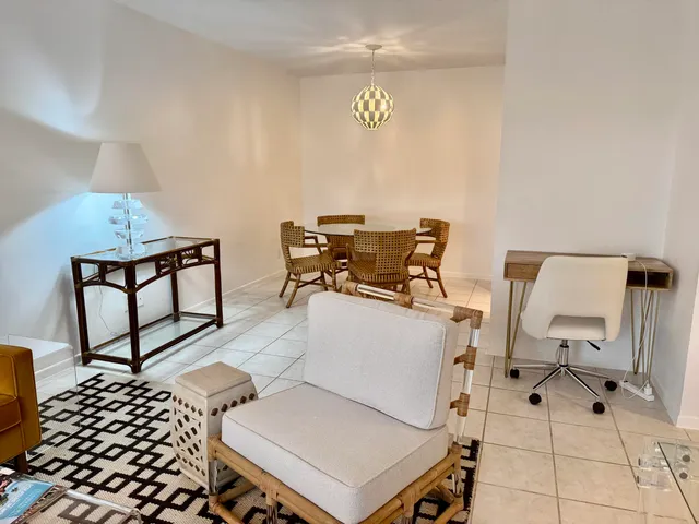 a living room with furniture a flat screen tv and a floor to ceiling window