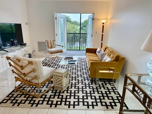a living room with furniture a flat screen tv and a large window