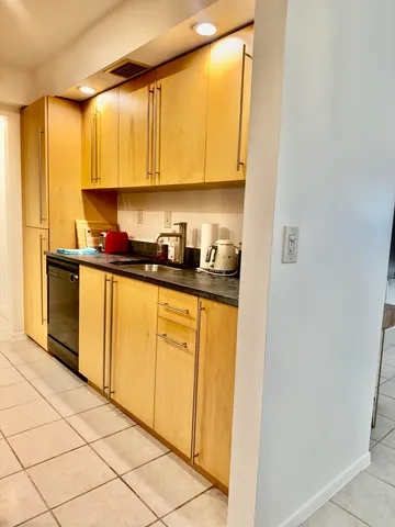a kitchen with a sink a stove top oven and cabinets