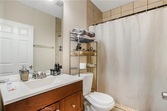 a bathroom with a sink a toilet a mirror and shower curtain