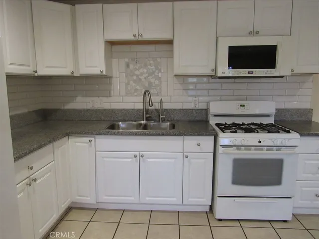 a kitchen with a stove sink and cabinets