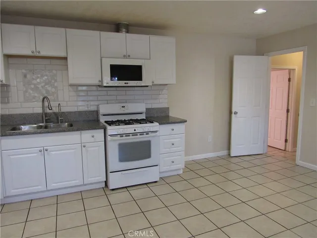 a kitchen with white cabinets stainless steel appliances and sink
