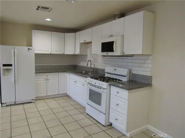 a close view of a sink a mirror and cabinets