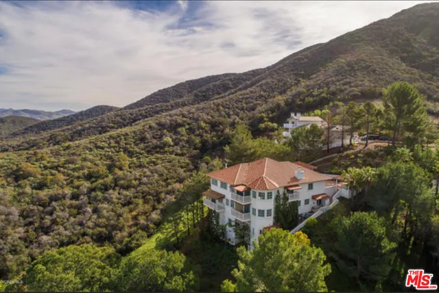 an aerial view of a house with a yard and outdoor seating