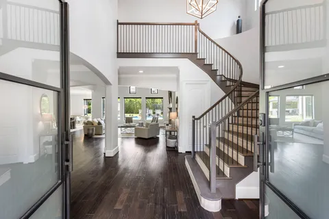 a living room with furniture a fireplace and a large mirror with wooden floor