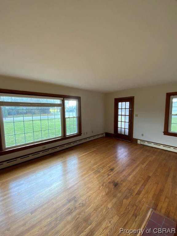 14 Light Street Heathsville, VA 22473 - Photo 4 of 18 Empty room with a wealth of natural light, a baseboard heating unit, and hardwood / wood-style flooring
