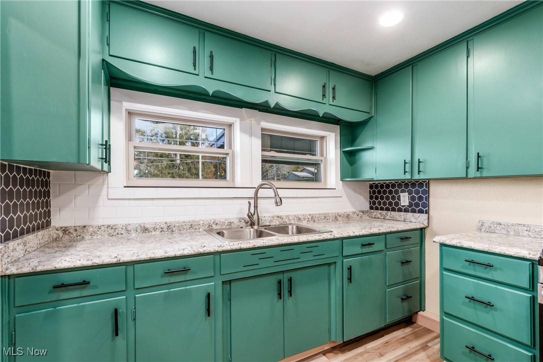 724 Garden Road Zanesville, OH 43701 - Photo 7 of 22 Kitchen with green cabinets, tasteful backsplash, and light wood finished floors