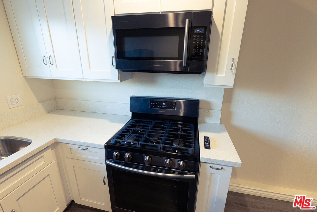 20102 Baltar Street Winnetka, CA 91306 - Photo 13 of 18 a kitchen with microwave cabinets and stove top oven