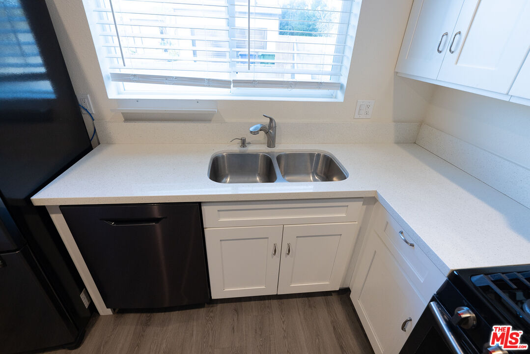 20102 Baltar Street Winnetka, CA 91306 - Photo 14 of 18 a kitchen with a sink window and cabinets